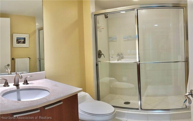 bathroom featuring vanity, toilet, and a shower with door