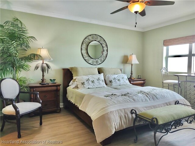 bedroom featuring light hardwood / wood-style flooring, ceiling fan, and crown molding