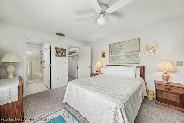 carpeted bedroom with a walk in closet, ensuite bathroom, a closet, and ceiling fan