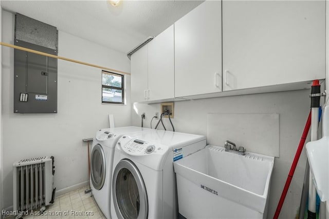 clothes washing area with cabinets, electric panel, sink, radiator heating unit, and washing machine and clothes dryer