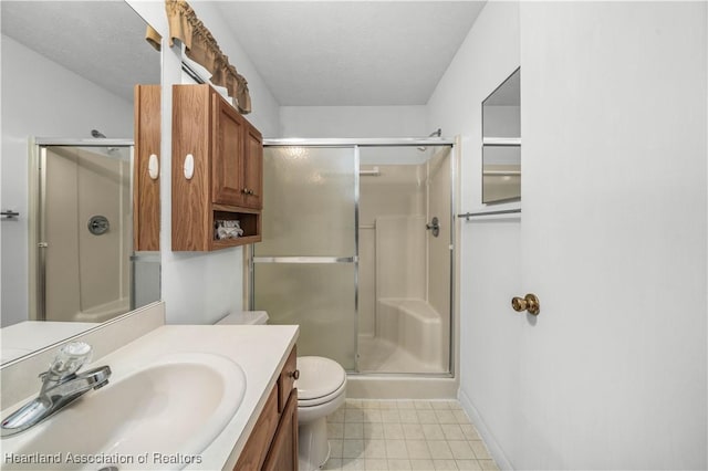 bathroom with a textured ceiling, vanity, toilet, and walk in shower