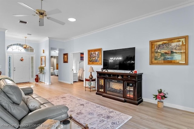 living room with a fireplace, light wood-type flooring, ceiling fan, and ornamental molding