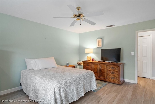 bedroom with ceiling fan, light hardwood / wood-style floors, and a closet