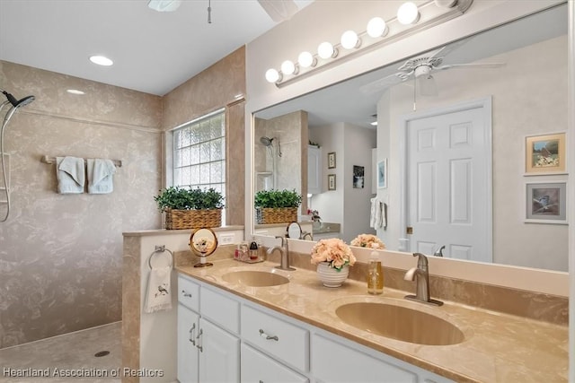 bathroom with vanity, ceiling fan, and tiled shower