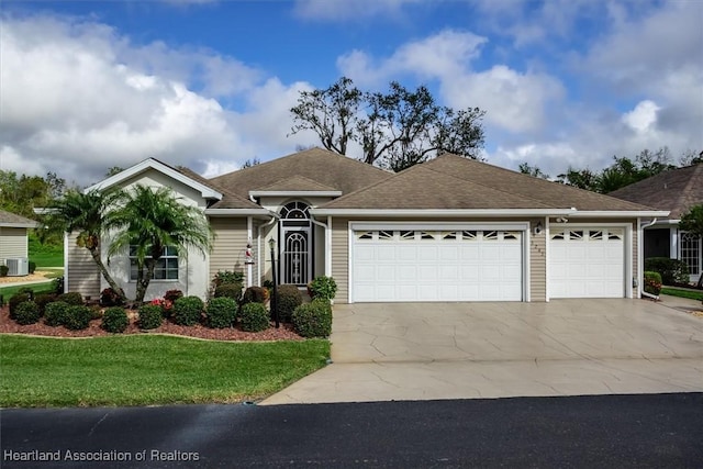 ranch-style home featuring cooling unit, a garage, and a front yard