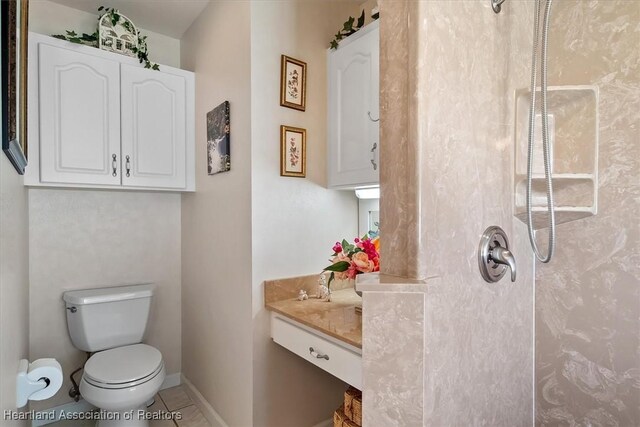 bathroom with tile patterned floors, toilet, vanity, and walk in shower