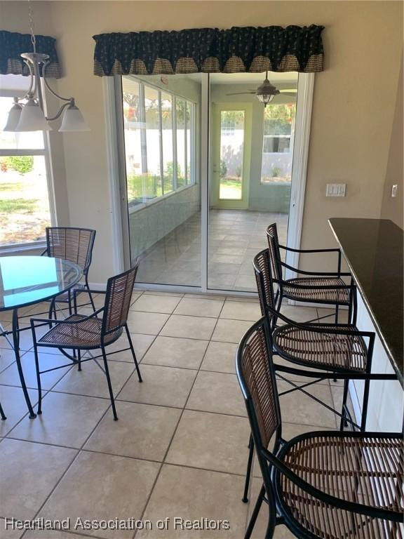 dining area with a healthy amount of sunlight, baseboards, and light tile patterned flooring