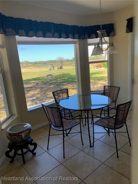 dining space with a healthy amount of sunlight, baseboards, and light tile patterned flooring