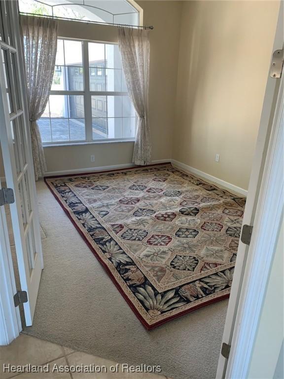 carpeted spare room with baseboards