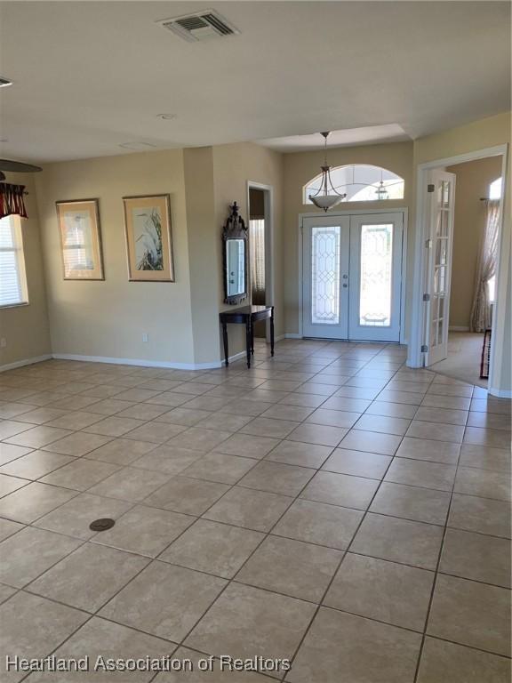 entryway with french doors, visible vents, baseboards, and light tile patterned flooring