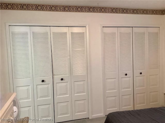 unfurnished bedroom with two closets