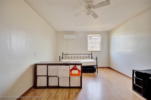 bedroom with light wood-type flooring and a wall unit AC