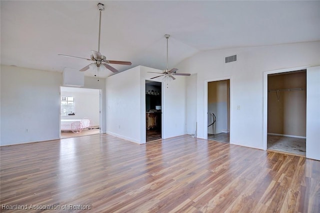 unfurnished living room featuring ceiling fan, wood-type flooring, and lofted ceiling