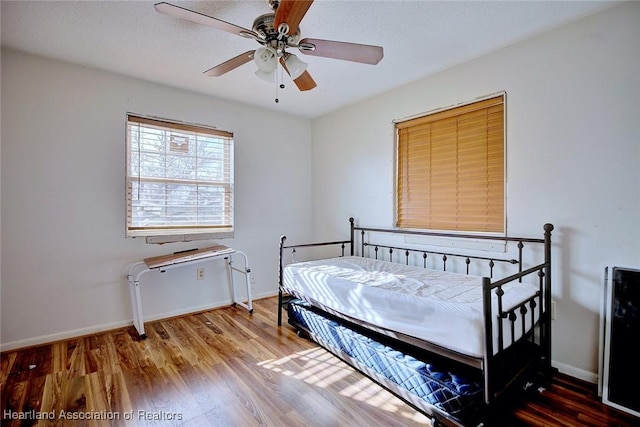 bedroom with ceiling fan and hardwood / wood-style flooring