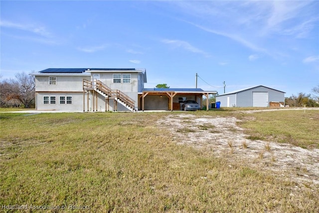 back of property with a garage and a yard