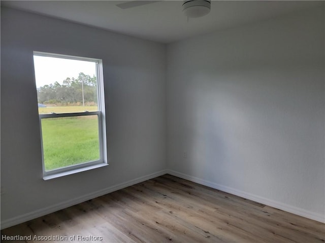 spare room with ceiling fan and light wood-type flooring