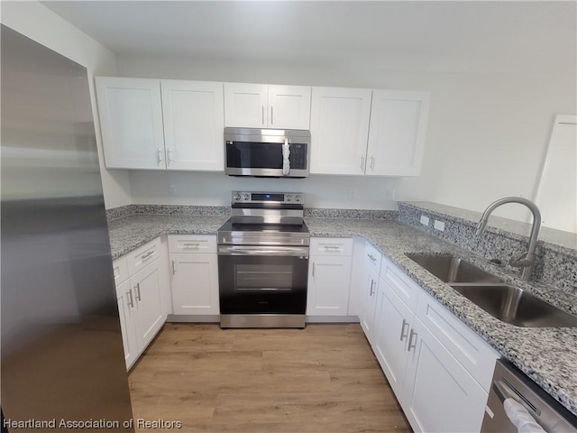 kitchen featuring white cabinetry, sink, and appliances with stainless steel finishes