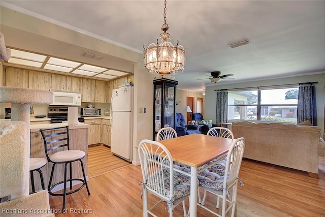 dining room featuring ceiling fan with notable chandelier and light wood-type flooring