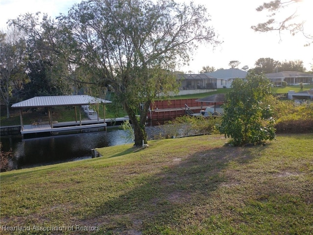 view of dock featuring a yard and a water view