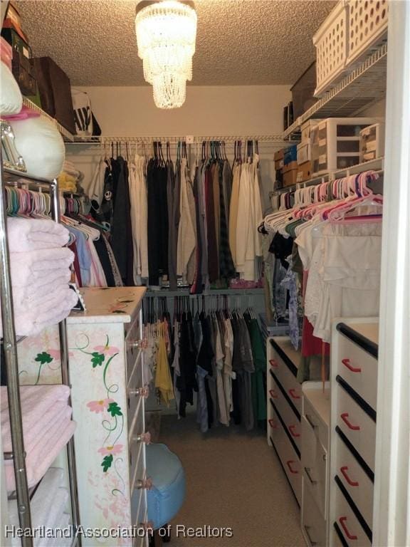 walk in closet featuring a chandelier