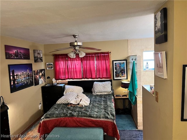 bedroom featuring ceiling fan, a textured ceiling, and dark colored carpet