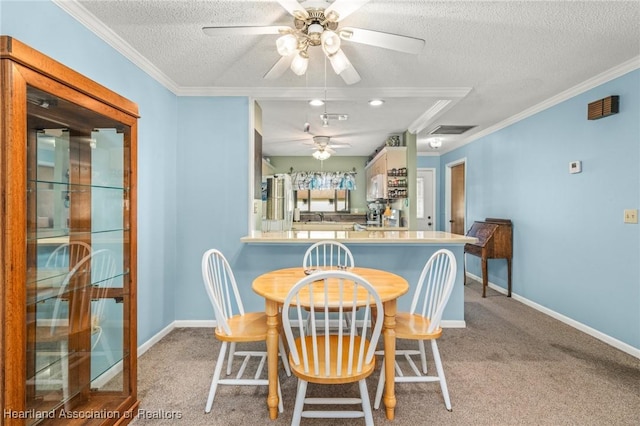 dining area with ornamental molding, light colored carpet, ceiling fan, and a textured ceiling