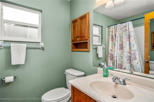 bathroom with vanity, curtained shower, and toilet