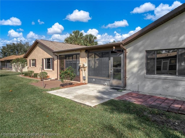 back of house featuring a lawn and a patio