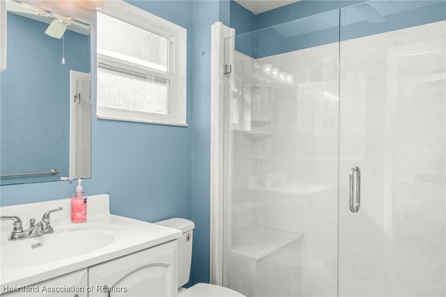 bathroom featuring an enclosed shower, vanity, and toilet