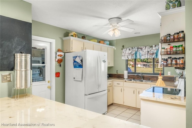 kitchen featuring ceiling fan, sink, white fridge, and light tile patterned floors