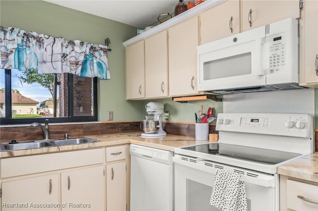 kitchen with sink, white appliances, and cream cabinets