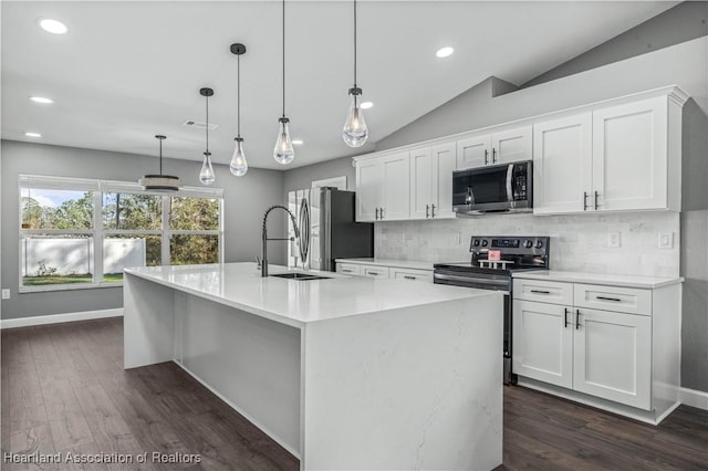 kitchen featuring stainless steel appliances, vaulted ceiling, decorative backsplash, and white cabinets