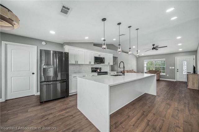 kitchen featuring white cabinetry, hanging light fixtures, appliances with stainless steel finishes, a kitchen island with sink, and backsplash