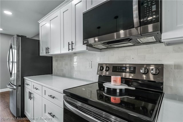 kitchen with white cabinetry, tasteful backsplash, appliances with stainless steel finishes, and wood-type flooring