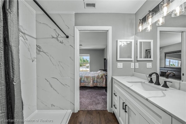 bathroom with vanity, hardwood / wood-style floors, and a shower