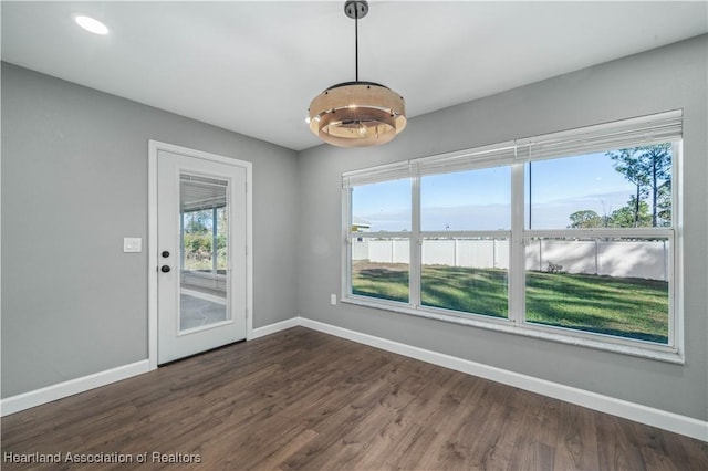 spare room with dark hardwood / wood-style floors, a healthy amount of sunlight, and a water view