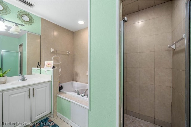 bathroom featuring tile patterned flooring, visible vents, a garden tub, a stall shower, and vanity