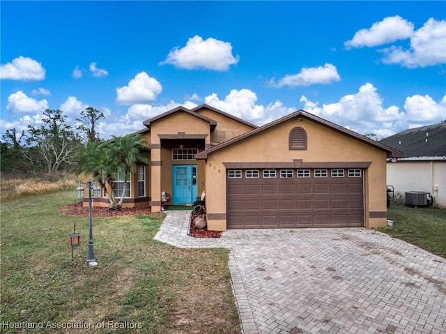 view of front of property with a front yard, central AC unit, stucco siding, a garage, and decorative driveway