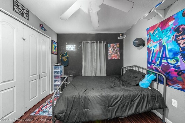 bedroom featuring baseboards, wood finished floors, and a ceiling fan