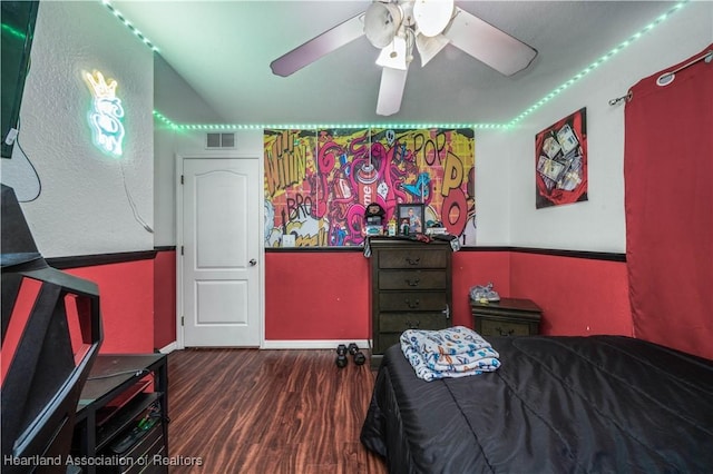 bedroom with a ceiling fan, wood finished floors, and visible vents