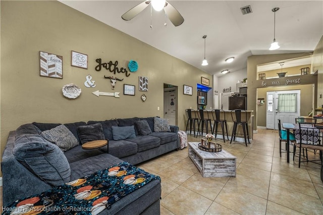 living area with visible vents, ceiling fan, baseboards, lofted ceiling, and light tile patterned floors