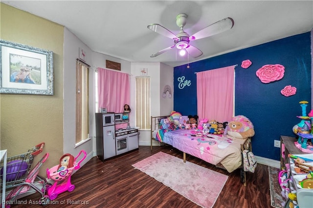 bedroom with dark wood-type flooring, a ceiling fan, and baseboards