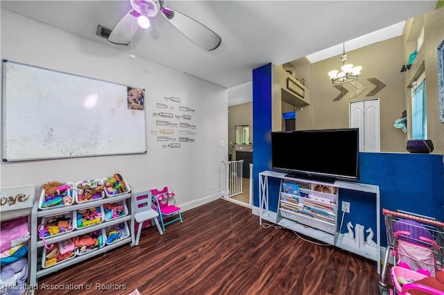 game room featuring ceiling fan with notable chandelier, baseboards, and wood finished floors