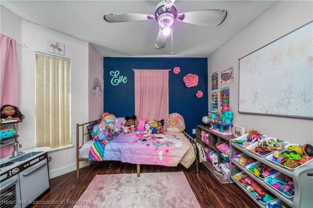 bedroom featuring ceiling fan, baseboards, and wood finished floors