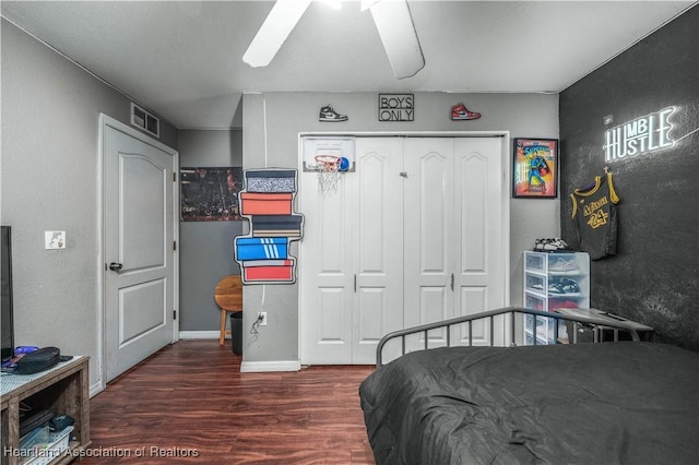 bedroom featuring visible vents, baseboards, wood finished floors, a closet, and a ceiling fan