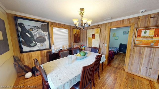 1102 W Gibson St, Arcadia, FL 34266 - dining area with a chandelier, crown molding, wood walls, and wood finished floors