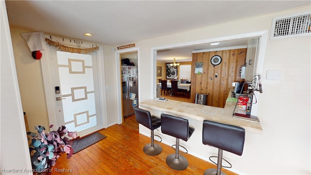 1102 W Gibson St, Arcadia, FL 34266 - kitchen featuring stainless steel refrigerator with ice dispenser, wood finished floors, a kitchen bar, recessed lighting, and light countertops
