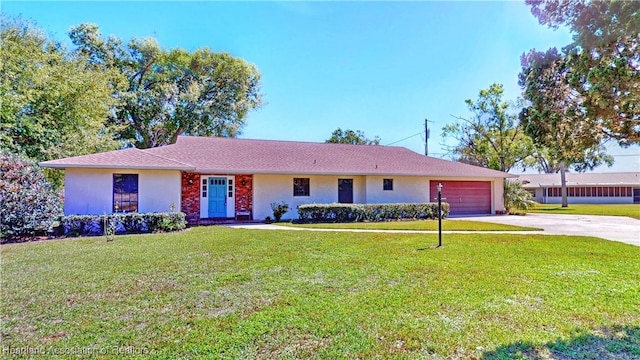 ranch-style house with concrete driveway, an attached garage, a front lawn, and stucco siding