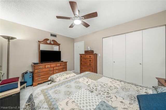 bedroom with ceiling fan, a textured ceiling, and a closet