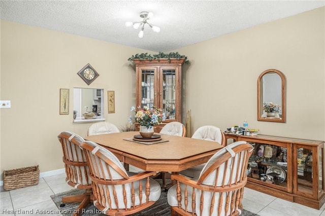 tiled dining room with a notable chandelier and a textured ceiling